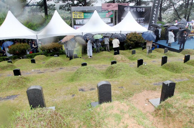 국가보훈처가 5.18 30주년 기념식에서 '임을 위한 행진곡' 제창 순서를 빼자 시민사회단체들이 인근 5.18 구묘역에서 별도의 기념식을 열고 있다.
