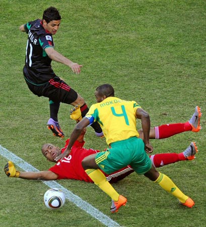 11일(현지시간) 남아프리카공화국(이하 남아공) 요하네스버그 사커시티 스타디움에서 열린 2010 남아공월드컵 조별예선 A조 남아공-멕시코 경기, 멕시코 카를로스 벨라(왼쪽)와 남아공 이투멜렝 쿠네 골키퍼(가운데), 아론 모쿠나가 볼다툼을 벌이고 있다.