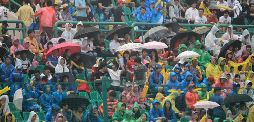 18일 오후 비가 내리는 가운데 프로야구 SK-KIA 경기가 열린 인천 문학구장에서 관중들이 우산과 비옷으로 비를 막으며 경기를 관전하고 있다.