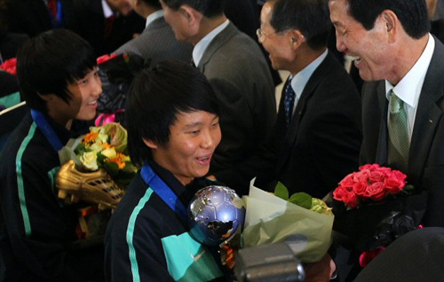 여자축구대표팀의 여민지 선수(왼쪽)와 김아름 선수가 28일 오후 인천국제공항으로 귀국하며 꽃다발을 받고 있다. 이들은 2010 국제축구연맹(FIFA) 17세 이하(U-17) 여자월드컵에서 한국축구 사상 최초로 우승을 차지했다.