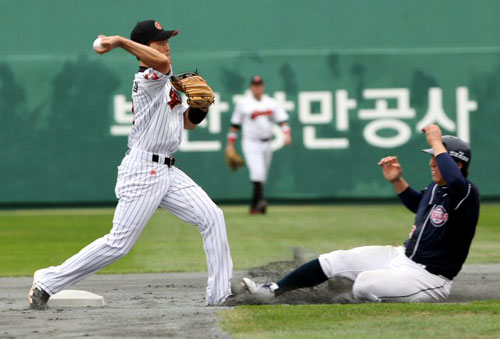 2일 부산 사직구장에서 열린 2010 프로야구 준플레이오프 두산 베어스-롯데 자이언츠 3차전. 7회초 1루에서 두산 김동주의 내야땅볼을 롯데 2루수 조성환이 두산 1루수 김현수를 아웃시킨뒤 1루로 던져 병살처리하고 있다.