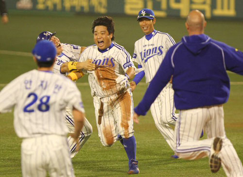 13일 오후 대구 시민운동장에서 열린 2010 프로야구 포스트시즌 플레이오프 5차전 두산베어스 대 삼성라이온즈의 경기 11회말 2사 만루 상황에서 삼성 박석민이 끝내기 안타를 친 뒤 환호하자 동료들이 달려들고 있다.