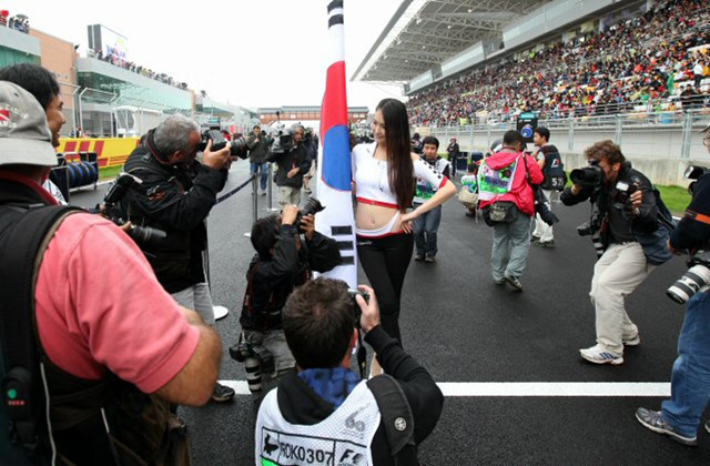 24일 영암 인터내셔널 서킷에서 열린 2010 F1 코리아 그랑프리 결승전에서 외신기자들이 태극기를 든 레이싱 모델을 취재하고 있다.