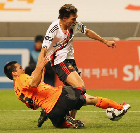 27일 제주월드컵경기장에서 열린 2010 K리그 제주 유나이티드-FC서울 경기, 제주 강준우(왼쪽)가 서울 데얀을 잡고 늘어지며 태클을 하고 있다. 1위 제주와 2위 서울은 1대1 무승부로 경기를 마쳤다.