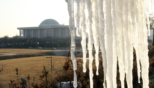 15일 오전 멀리 국회의사당이 보인 서울 여의도 한강변에서 고드름이 얼음 정국을 알리고 있다.