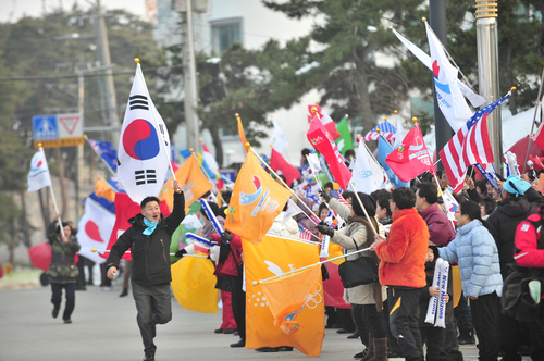 2018 평창동계올림픽에 대한 IOC 조사평가단의 현지실사 사흘째인 18일 강릉 경포해변에서 주민들이 깃발을 흔들며 평가단을 환영하고 있다.