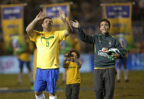 8일(한국시간) 브라질 상파울루 파카엥부 경기장에서 열린 친선경기 브라질-루마니아 경기에서 은퇴식을 가진 브라질의 호나우두(왼쪽)가 두 아들과 함께 팬들에게 인사를 하고 있다.