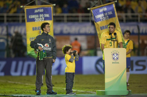 8일(한국시간) 브라질 상파울루 파카엥부 경기장에서 열린 친선경기 브라질-루마니아 경기에서 은퇴식을 가진 호나우두(오른쪽)가 인사말을 하는 동안 작은 아들이 촬영을 하고 있다.