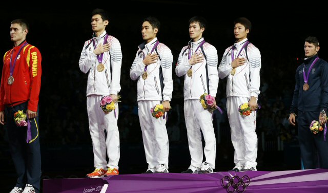 한국 남자 펜싱 사브르 대표팀 선수들이 4일 영국 런던 사우스 아레나에서 열린 2012 런던올림픽에서 단체전 시상식에서 금메달을 목에 걸고 국기에 대한 경례를 하고 있다. 왼쪽부터 구본길,김정환,원우영,오은석.