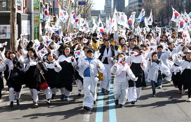 한복을 입은 학생들이 1일 오전 서울 종로 인사동에서 열린 '제94회 3.1 만세의 날 거리축제'를 마친 후 태극기를 흔들며 종로거리를 뛰고 있다. 