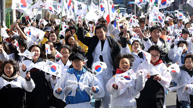 한복을 입은 학생들이 1일 오전 서울 종로 인사동에서 열린 '제94회 3.1 만세의 날 거리축제'를 마친 후 보신각을 향해 행진을 하며 태극기를 흔들고 있다.