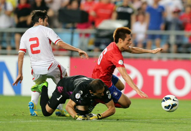 18일 울산 문수월드컵경기장에서 열린 2014 브라질 월드컵 최종 예선 한국과 이란의 경기에서 한국의 이명주(오른쪽)가 이란 헤이다리(왼쪽), 이란 GK 아흐마디와 몸싸움을 벌이다 넘어지고 있다.