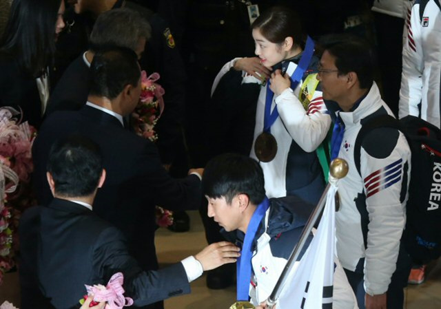 2014 소치 동계올림픽에 참가한 한국 단 김연아, 이규혁 등이 25일 오후 인천국제공항을 통해 귀국하며 대한체육회가 준비한 초콜릿 금메달을 목에 걸고 있다. 