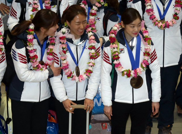 2014 소치 동계올림픽에 참가한 한국 선수들이 25일 오후 인천국제공항을 통해 귀국하며 대한체육회가 준비한 초콜릿 금메달을 목에 걸고 있다.