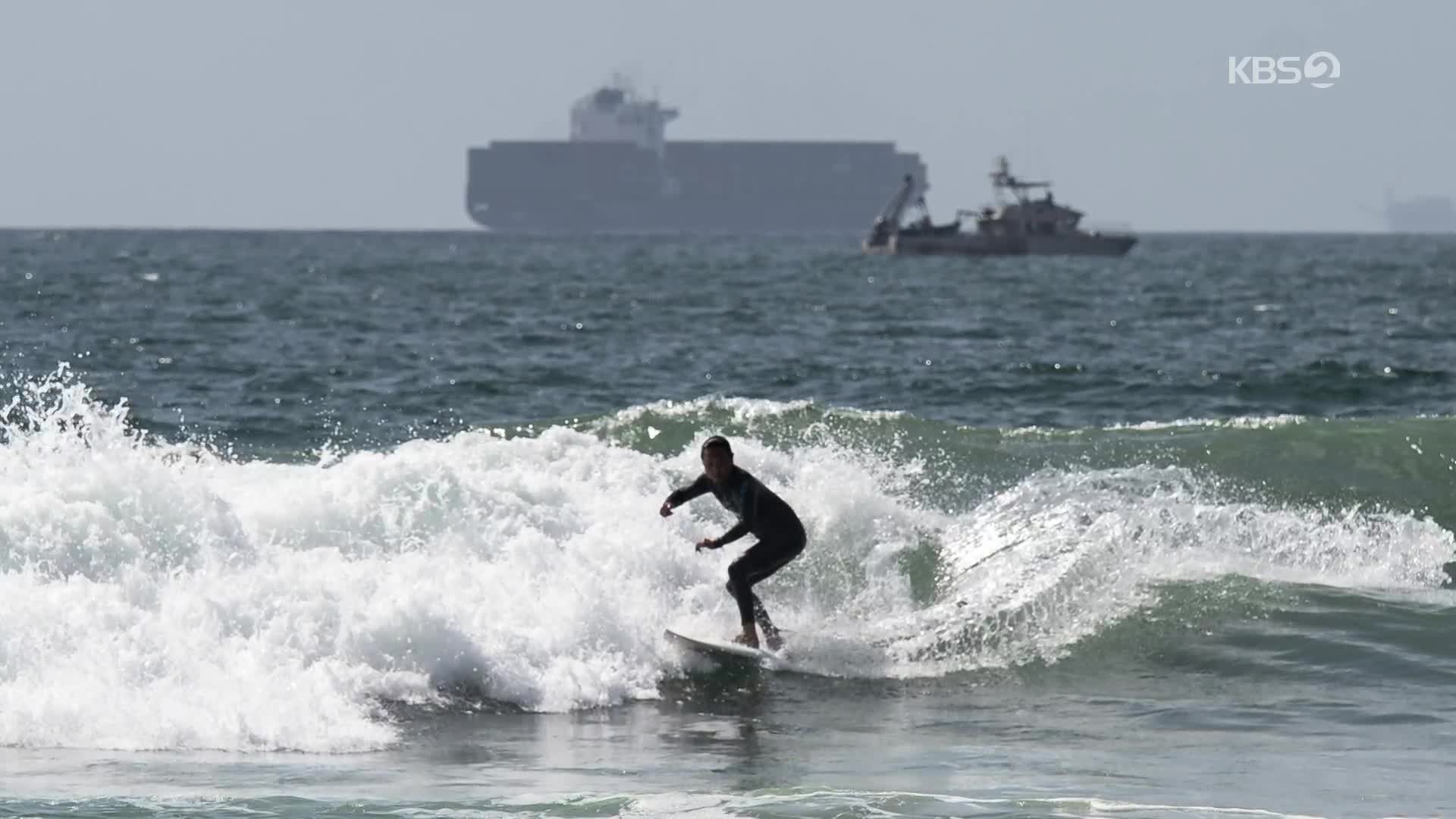[지구촌 포토] 기름 제거 중인 해변 서핑하는 피서객
