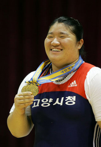 11일 오후 광주 정광고 체육관에서 열린 제88회 전국체육대회 역도 여자 일반부 75kg 이상급에 출전한 장미란이 인상 126kg, 용상 174kg, 합계 300kg을 들어올려 금메달 3개와 함께 대회신기록을 세운 뒤 활짝 웃고 있다. 