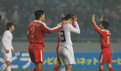 20일 오후 중국 충칭에서 열린 동아시아 선수권 축구대회 대한민국-북한전에서 1:1로 양팀이 비기자 북한팀 차정혁이 한국의 이상호를 위로하고 있다. 다른 북한팀 선수들은 환호하고 있다. 