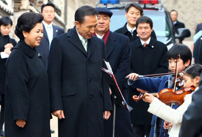 25일 이명박 대통령과 영부인 김윤옥 여사가 국회의사당에서 열리는 제17대 대통령 취임식에 참석하기 위해 서울 가회동 자택을 나서다 어린이들의 바이올린 연주를 선사받고 있다. 