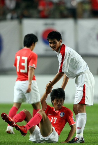 22일 서울월드컵경기장에서 벌어진 월드컵 3차 예선에서 북한의 안영학이 넘어진 한국의 이청용의 손을 잡고 일으켜 세워주고 있다. 
 