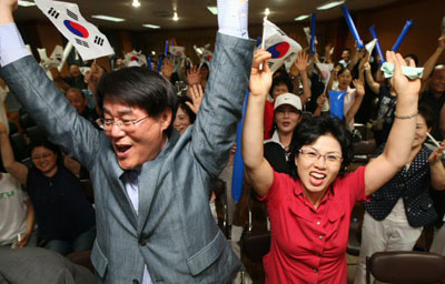 11일 오후 경기도 안산시청에서 베이징올림픽 남자 양궁 한국과 이탈리아의 결승전을 지켜보던 대표팀 이창환 선수의 아버지 이광식씨와 어머니 박영희씨가 한국팀의 금메달이 확정되자 환호하고 있다. 