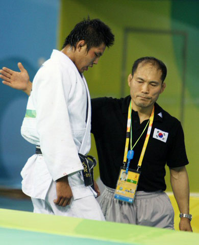 12일 베이징과학기술대학교에서 열린 유도 남자 81kg급 결승에서 한국의 김재범이 독일의 올레 비쇼프에게 패한 뒤 아쉬워하자 안병근 감독이 위로하고 있다. 