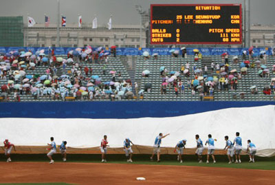 14일 오후 베이징 우커송야구장에서 열린 올림픽 야구 한국 대 중국 경기에서 한국이 득점 찬스를 맞은 4회말 우천으로 경기가 중단되고 있다. 