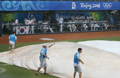 14일 오후 베이징 우커송야구장에서 열린 올림픽 야구 한국 대 중국 경기에서 한국이 득점 찬스를 맞은 4회말 우천으로 경기가 중단되고 있다. 