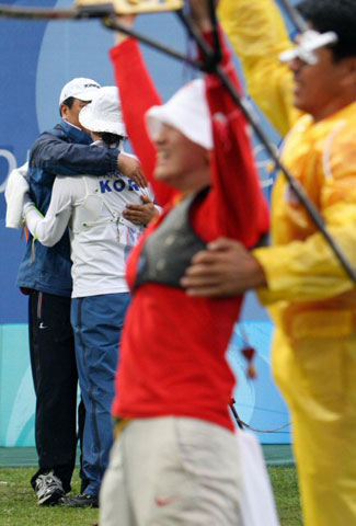 14일 베이징 올림픽 그린 양궁 경기장에서 열린 여자 개인전 결승에서 중국의 장 위엔위엔이 우승의 기쁨을 나누고 있는 동안 은메달에 그친 박성현이 문형철 감독과 함께 아쉬워하고 있다. 