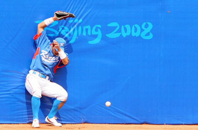 18일 중국 베이징 우커송야구장에서 열린 2008 베이징올림픽 야구 예선 대한민국-타이완 경기에서 한국 중견수 이종욱이 7회말, 타이완 린치셍의 타구를 잡으려다 펜스에 부딪치며 공을 놓치고 있다. 