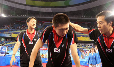18일 중국 베이징대학 체육관에서 열린 2008 베이징올림픽 탁구 남자 단체 동메달결정전 대한민국-오스트리아 경기에서 마지막 단식을 승리로 이끈 유승민(가운데)이 유남규 코치(오른쪽)의 격려를 듣고 있다. 