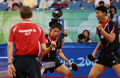 18일 중국 베이징대학 체육관에서 열린 2008 베이징올림픽 탁구 남자 단체 동메달결정전 대한민국-오스트리아 경기에서 복식에 나선 윤재영(가운데)-오상은(오른쪽)이 득점에 성공한 후 환호하고 있다. 