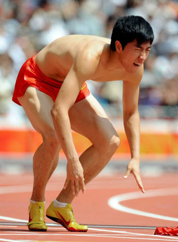 18일(현지시간) 중국 베이징 궈자티위창에서 열린 2008 베이징올림픽 육상 남자 110ｍ 허들 예선에서 중국의 육상 영웅 류시앙이 레이스를 앞두고 아킬레스건 부상으로 고통스런 표정을 짓고 있다. 