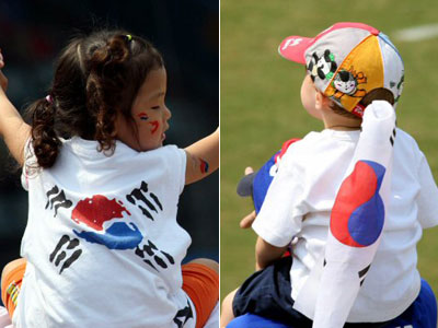 19일 중국 베이징 우커송야구장에서 열린 2008 베이징 올림픽 야구 예선 대한민국-쿠바 경기에서 어린이 관중이 태극기가 새겨진 옷과 모자를 쓰고 목마를 탄 채 응원하고 있다. 