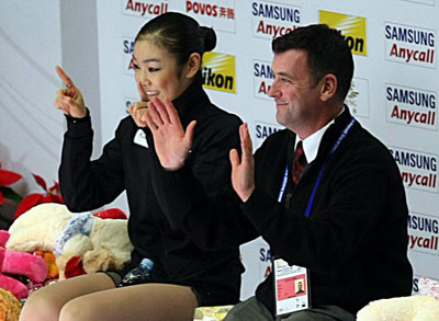   '피겨 퀸' 김연아가 6일 오후 중국 베이징 수도체육관에서 열린 2008-2009 국제빙상경기연맹(ISU) 시니어 피겨스케이팅 그랑프리 3차 대회 '컵 오브 차이나' 여자 싱글 쇼트프로그램에서 환상적인 연기를 펼친 후 브라이언 오서 코치와 함께 앉아 손가락으로 하트를 그리고 있다. 