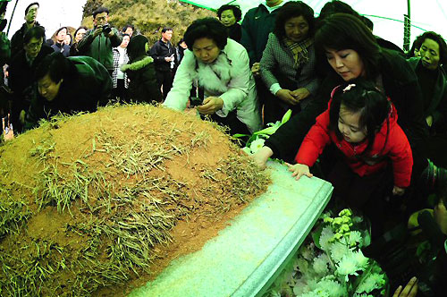 22일 오후 경기도 용인 천주교 성직자 묘역에서 열린 故 김수환 추기경 추모 미사에 참여한 많은 시민들이 김 추기경의 묘소에 꽃을 올리며 사랑 실천을 약속하고 있다. 