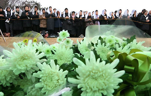22일 오후 경기도 용인 천주교 성직자 묘역에서 열린 故 김수환 추기경 추모 미사에 참여한 많은 시민들이 김 추기경에게 올려진 꽃 앞에서 기도하고 있다. 