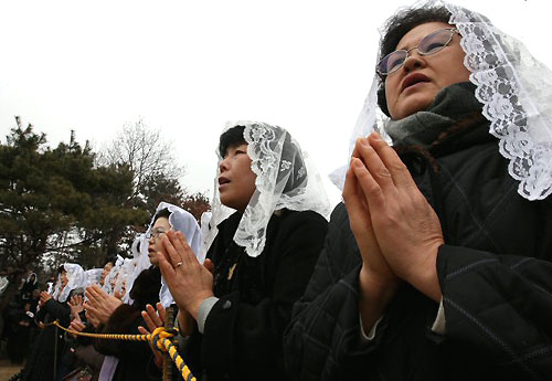 22일 오후 경기도 용인 천주교 성직자 묘역에서 열린 故 김수환 추기경 추모 미사에 참여한 많은 시민들이 김 추기경의 안식을 위해 기도하고 있다. 