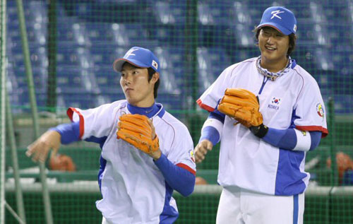 6일 일본 도쿄돔에서 2009 월드베이스볼클래식(WBC) 첫 경기 타이완전을 앞둔 대한민국 야구 대표팀 이대호(오른쪽)가 고영민의 훈련 모습을 지켜보고 있다. 