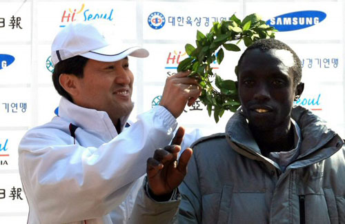 15일 서울 시내 일원에서 열린 2009 서울국제마라톤대회에서 1위를 차지한 케냐의 모세스 아루세키(오른쪽)가 오세훈 서울 시장으로부터 월계관을 받고 있다. 