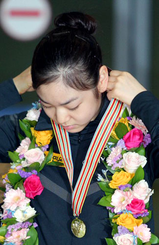  세계 최초로 피겨 여자 싱글 부문 200점을 돌파하며 세계선수권대회를 우승한 김연아가 31일 오후 인천국제공항을 통해 입국, 취재진의 요청에 금메달을 목에 걸고 있다. 