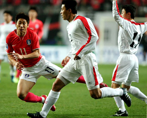 1일 서울월드컵경기장에서 벌어진 2010년 남아공월드컵 아시아예선 한국-북한전에서 이근호가 북한 문인국(뒤), 차정혁 사이로 돌파하다 넘어지고 있다. 