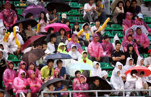 20일 광주무등경기장에서 벌어진 2009 프로야구 KIA 타이거즈와 LG 트윈스의 경기에서 비가 내리면서 관중들이 비옷과 우산을 쓰고 경기를 지켜보고 있다. 