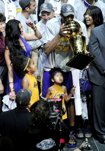 15일(현지시각) 미국 플로리다주 올랜도 암웨이 아레나에서 열린 2009-2009 NBA 챔피언결정전(7전 4선승제) 올랜도 매직과 LA 레이커스의 5차전 경기에서 레이커스의 가드 코비 브라이언트가 그의 가족과 함께 트로피에 키스하고 있다. 