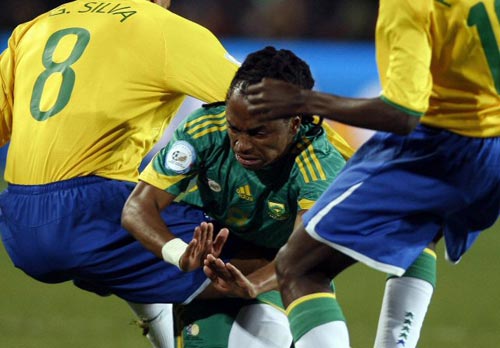 25일(현지시간) 남아프리카공화국 요하네스버그 엘리스 파크에서 열린 2009 국제축구연맹(FIFA) 컨페더레이션스컵 4강, 남아공 시피위 차발랄라(가운데)가 브라질 라미레스(오른쪽), 질베르토 실바 사이에서 넘어지고 있다. 