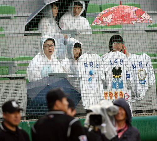  30일 프로야구 삼성 라이온즈-KIA 타이거즈전이 열릴 예정이던 대구구장에 비가 내리자 삼성 라이온즈 팬들이 경기진행 여부에 대한 심판원들의 결정을 기다리고 있다. 