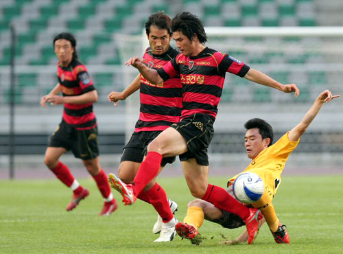 1일 경기 고양종합운동장에서 벌어진 2009하나은행FA컵 고양국민-포항전에서 고양국민 김현기(오른쪽)가 포항 선수들 뒤에서 태클로 공을 뽑아내고 있다. 