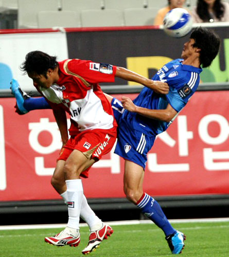 1일 부산 아시아드주경기장에서 열린 프로축구 2009 하나은행 FA컵 본선 16강 부산-수원 경기에서 수원 서동현(오른쪽)이 부산 홍성요의 헤딩에 앞서 공을 차내고 있다. 