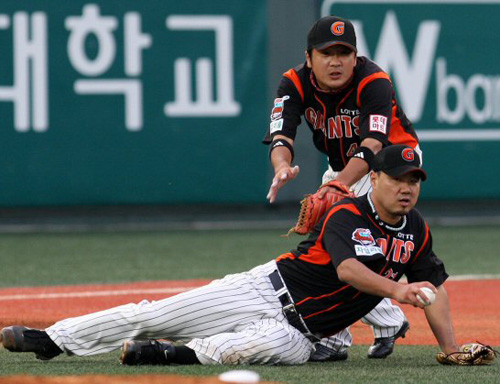   10일 오후 목동야구장에서 열린 프로야구 히어로즈와 롯데 경기 3회말 무사, 롯데 선발투수 송승준이 황재균의 투수 앞 땅볼을 잡으려다 넘어진 뒤 송구에 실패하고 있다. 