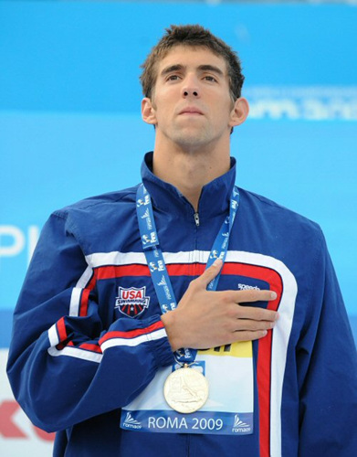 2일(한국 시간) 이탈리아 로마의 포로 이탈리코 콤플렉스에서 열린 2009 로마 세계수영선수권대회 남자 접영 100ｍ에서 세계신기록으로 우승한 펠프스가 금메달을 목에 걸고 국가가 울리는 동안 예를 갖추고 있다. 