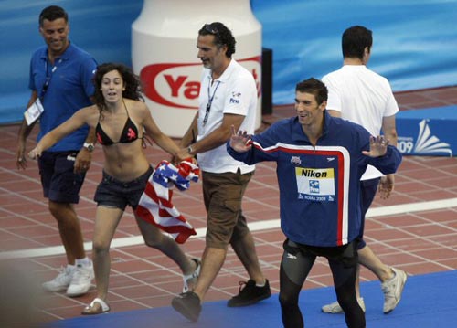 2일(현지시간) 이탈리아 로마 포로 이탈리코 수영장에서 열린 국제수영연맹(FINA) 2009 세계수영선수권, 미국의 수영 황제 마이클 펠프스가 남자 4x100m 혼계영 금메달을 받기 위해 시상대로 가던 중 한 여성팬이 자신을 포옹하기 위해 나타나자 웃고 있다. 